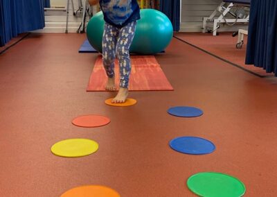 child having fun running during treatment in a specialist physiotherapy session improving balance and co- ordination